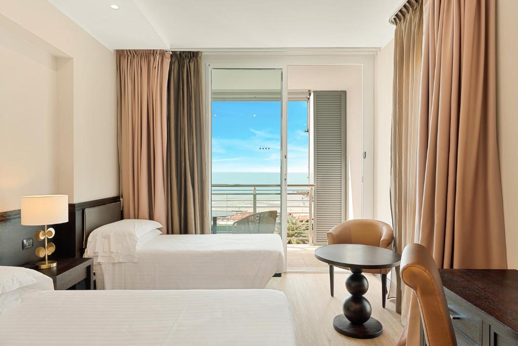 a hotel room with two beds and a view of the ocean at Hotel Excelsior in Marina di Massa