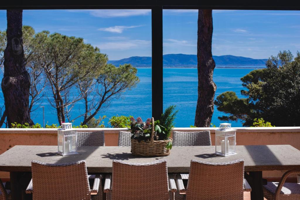a table with chairs and a view of the water at [porto s. stefano] place like heaven + parcheggio in Porto Santo Stefano