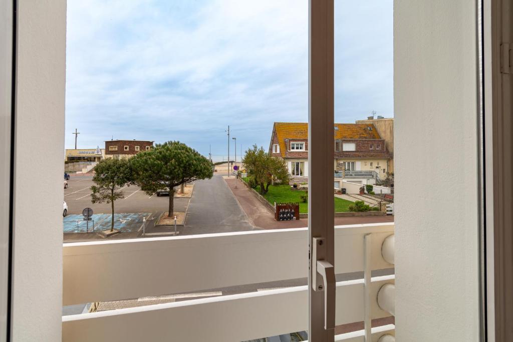 - une vue sur la rue depuis la fenêtre dans l&#39;établissement Hôtel De La Plage, à Courseulles-sur-Mer