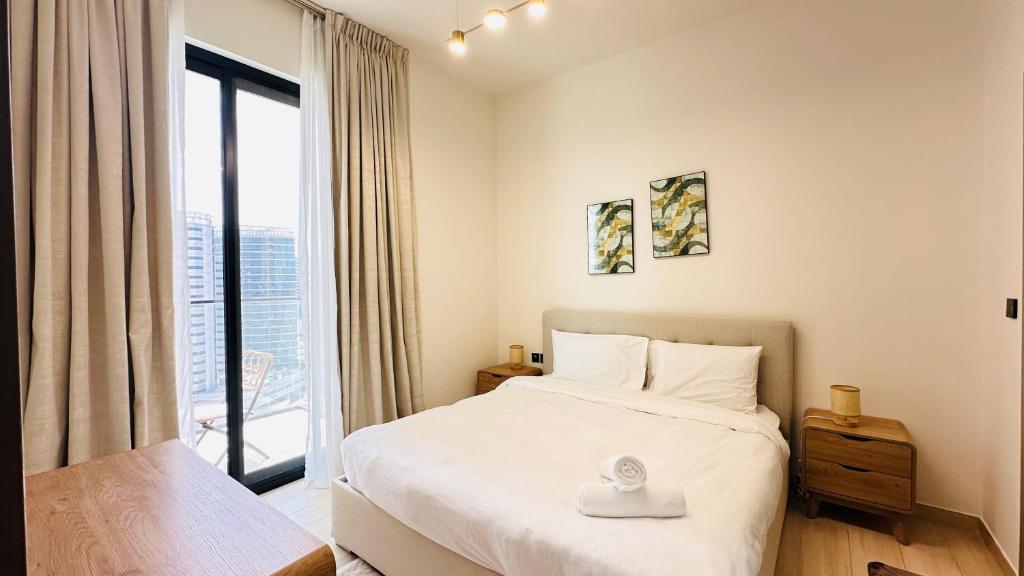 a bedroom with a bed and a large window at OYO 1290 Home Fully Furnished 1bed Apartment @JVC in Dubai