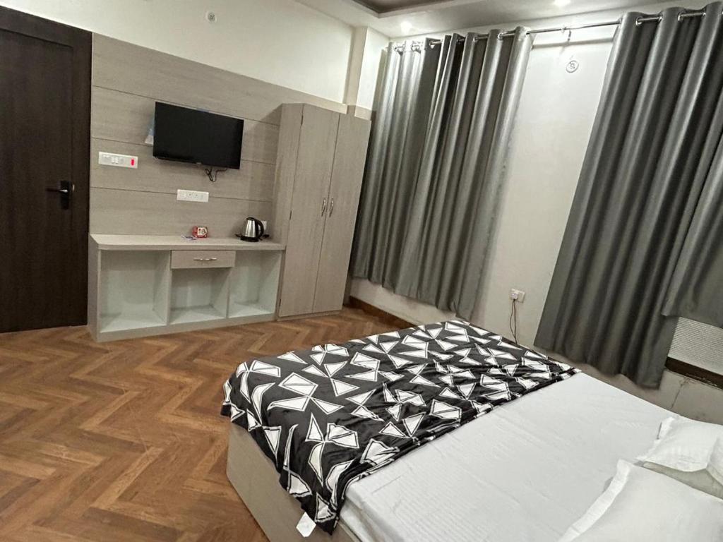 - une chambre avec un lit et une télévision dans l'établissement Nihaal Palace, à Ayodhya