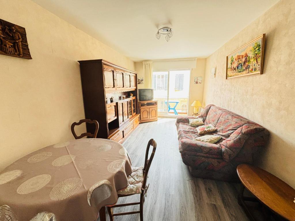 un salon avec une table et un canapé dans l'établissement Appartement Confortable à 100m de la Plage, Centre-ville Les Sables-d'Olonne - FR-1-197-593, à Les Sables-dʼOlonne