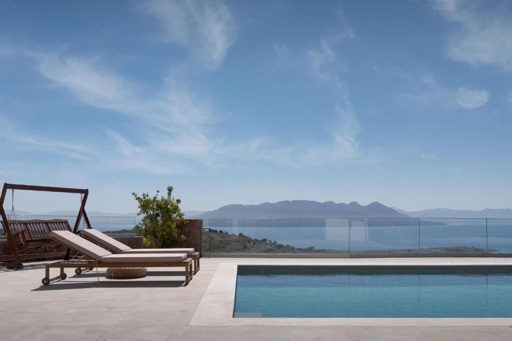 a swimming pool with a lounge chair next to a swimming pool at Kaerati Villa Aegina in Aegina Town