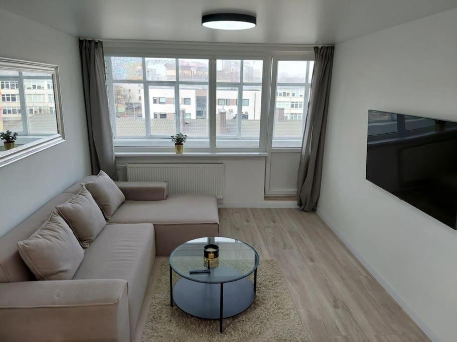 a living room with a couch and a glass table at Central w/free parking & Netflix in Vilnius