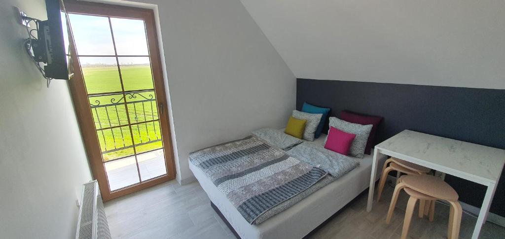 Habitación pequeña con cama, mesa y ventana en Apartamenty i pokoje TT Mielno ALLDAYHOLIDAY en Mielno