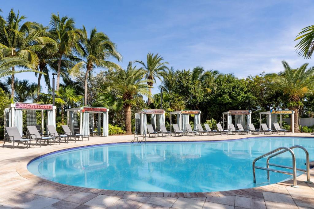 a swimming pool with chairs and palm trees at Fairfield Inn & Suites by Marriott Key West at The Keys Collection in Key West