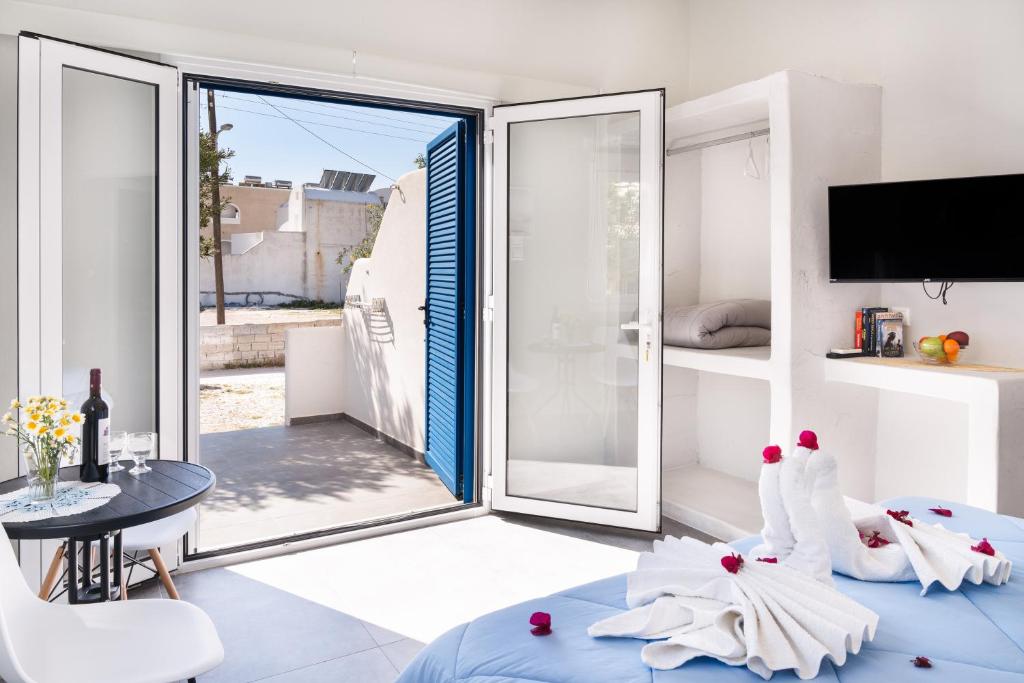 a room with a large sliding glass door with a table at Aegean Blue Santorini Perissa in Perissa