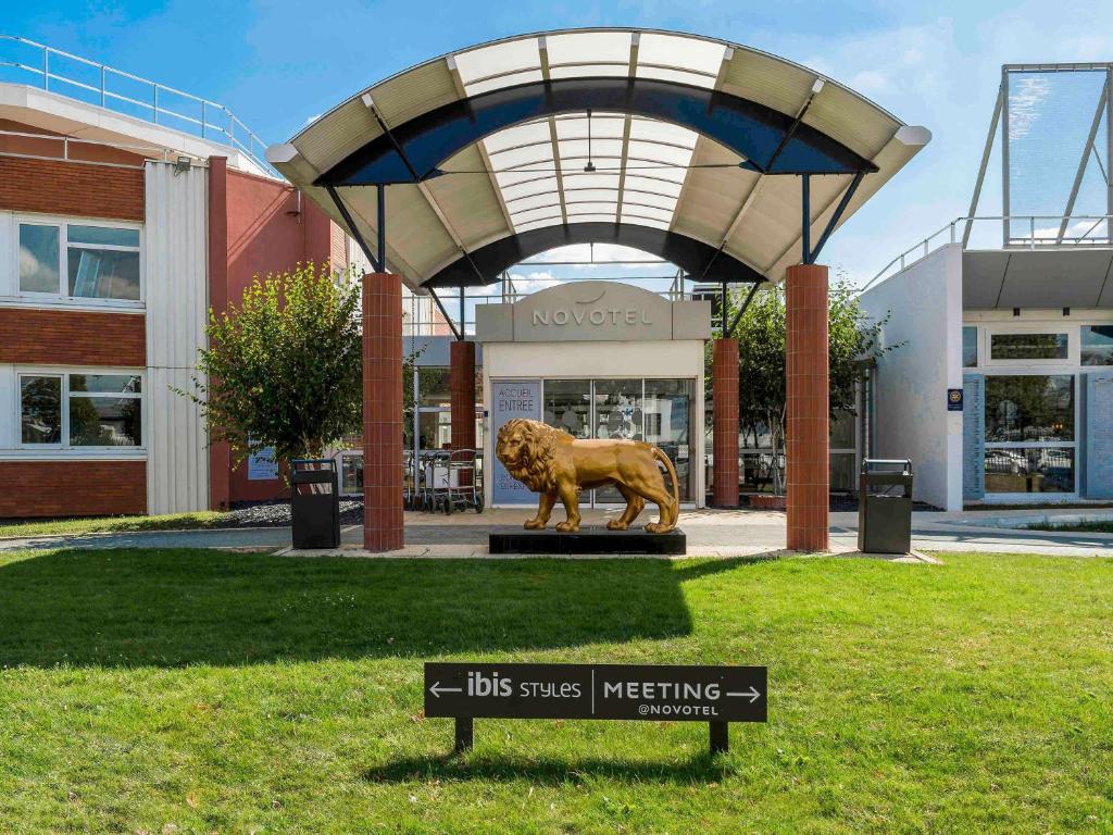 una estatua de un león frente a un edificio en Novotel Lyon Bron Eurexpo, en Bron