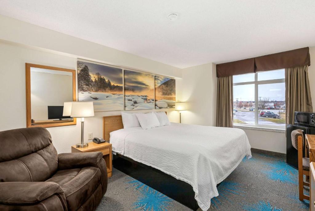 a hotel room with a bed and a couch at Days Inn by Wyndham Great Falls in Great Falls