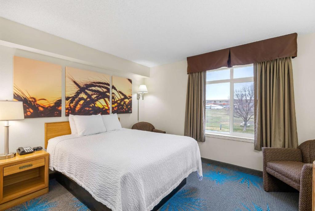 a hotel room with a bed and a window at Days Inn by Wyndham Great Falls in Great Falls
