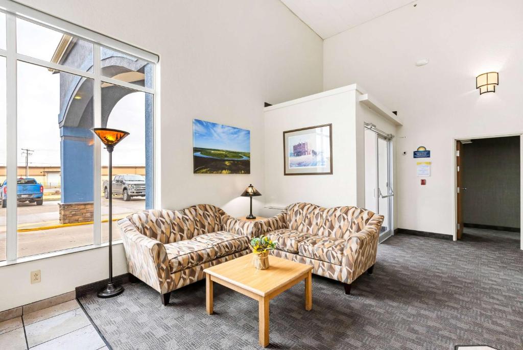 a living room with two couches and a table at Days Inn by Wyndham Great Falls in Great Falls