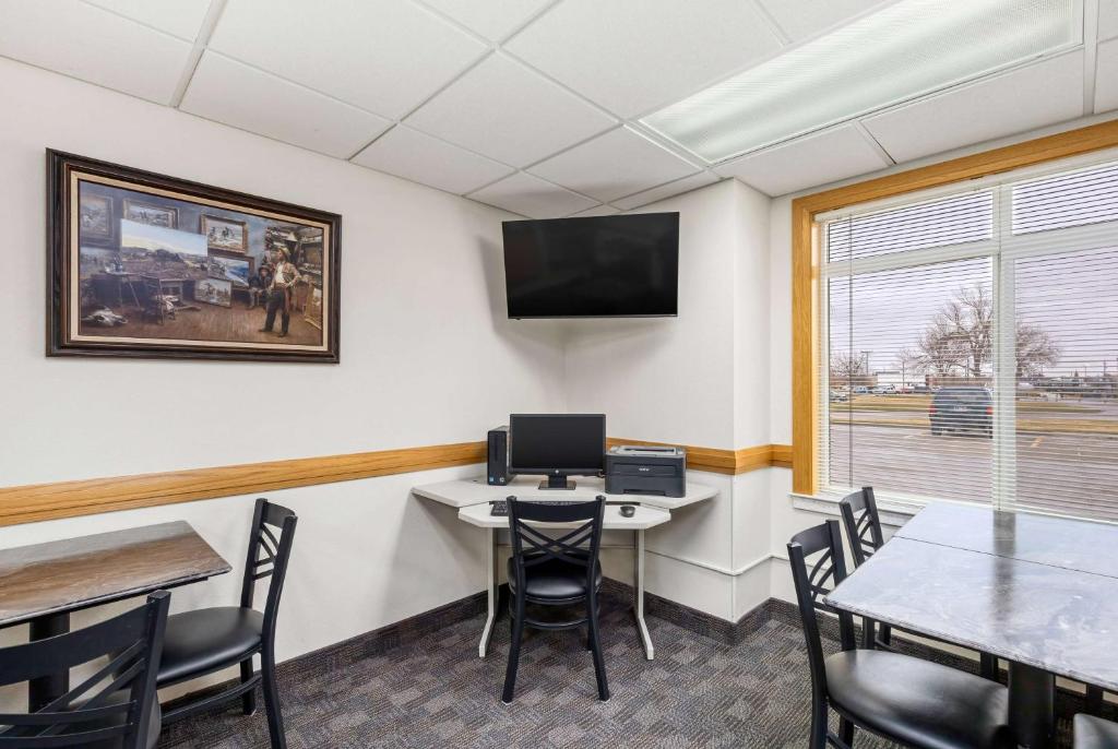 a meeting room with a table and chairs and a tv at Days Inn by Wyndham Great Falls in Great Falls