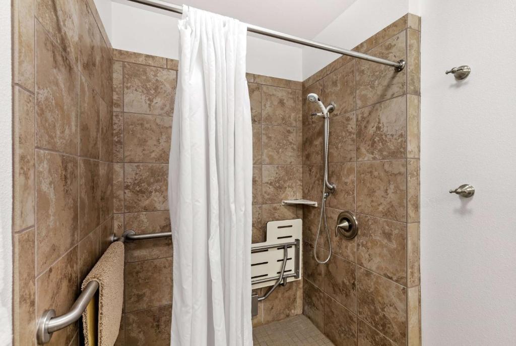 a shower with a shower curtain in a bathroom at Days Inn by Wyndham Great Falls in Great Falls