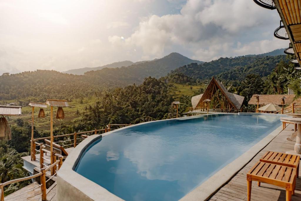 uma piscina num resort com montanhas ao fundo em Maha Hills Resort Lovina em Lovina