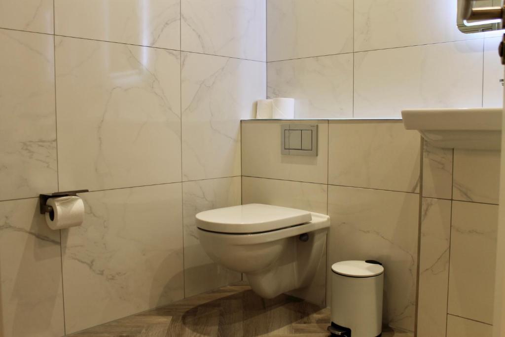 a white bathroom with a toilet and a sink at The California - London Kings Cross in London