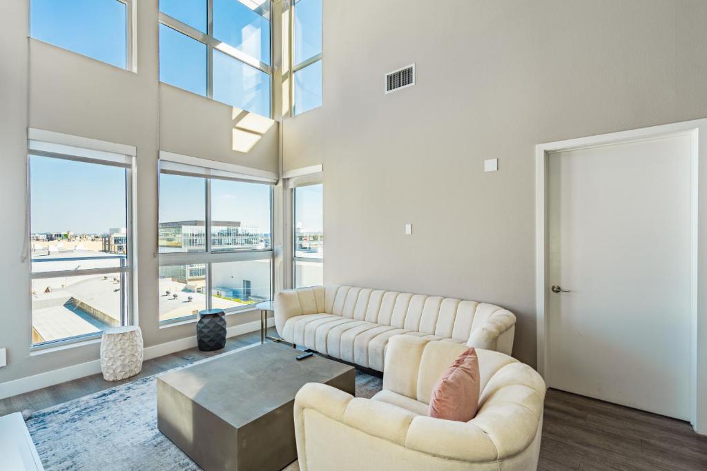 a living room with two couches and a table and windows at Luxury 3 Bedroom 2 Bath Loft! Beautiful Views in Los Angeles