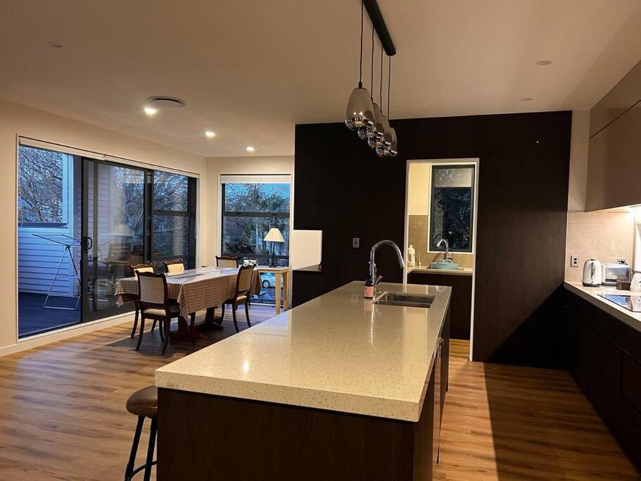 a kitchen with a counter top and a dining room at Brand New & Central - 3 Bedrooms with 3 En suites in Auckland