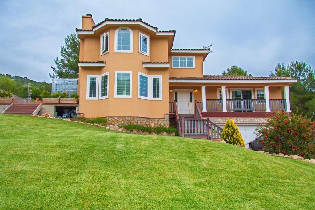 a large house with a large yard at Villa Sitges Mas Mestre in Viladellops