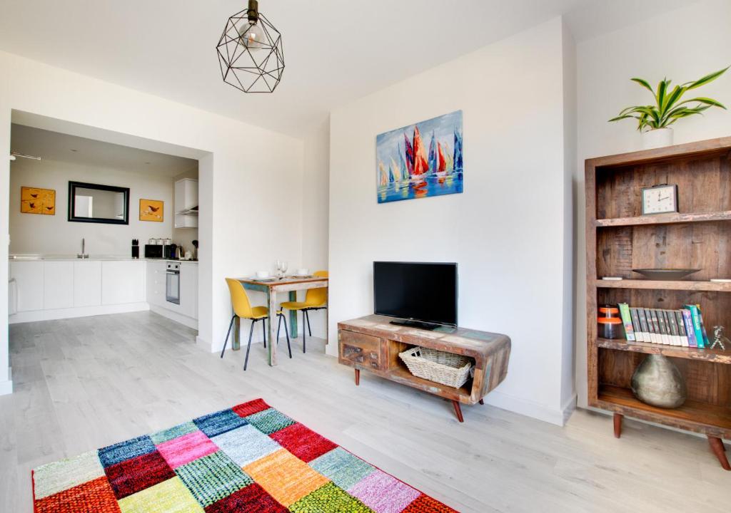 a living room with a television and a table at Phoebe’s - Ellinbrook Apartments in Hunstanton