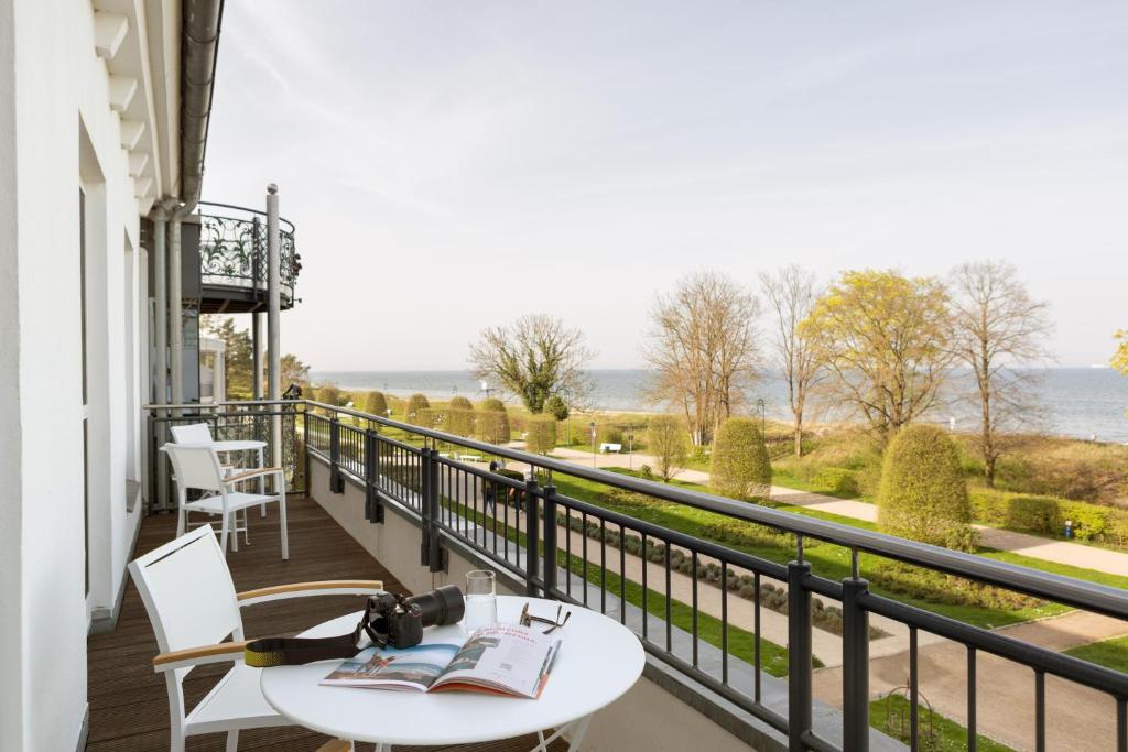 a balcony with a table and a view of the water at Hotel Kaiserhof Heringsdorf in Heringsdorf