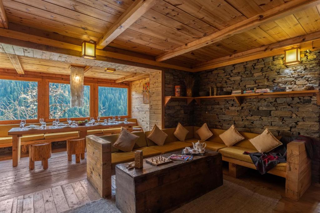 sala de estar con sofá y pared de piedra en Elivaas Skyline Luxury 4BHK Entire Home in Narkanda, en Shimla