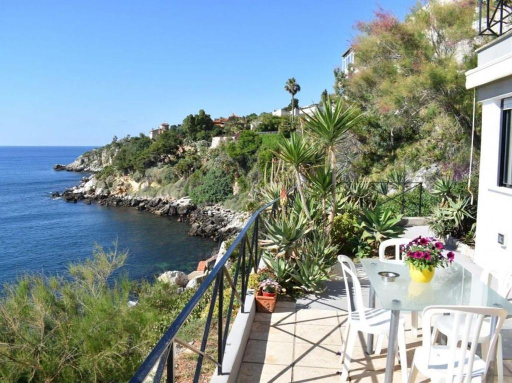 a balcony with a table and chairs overlooking the ocean at Vero Sicily - Villa Acqua Chiara in Bagheria