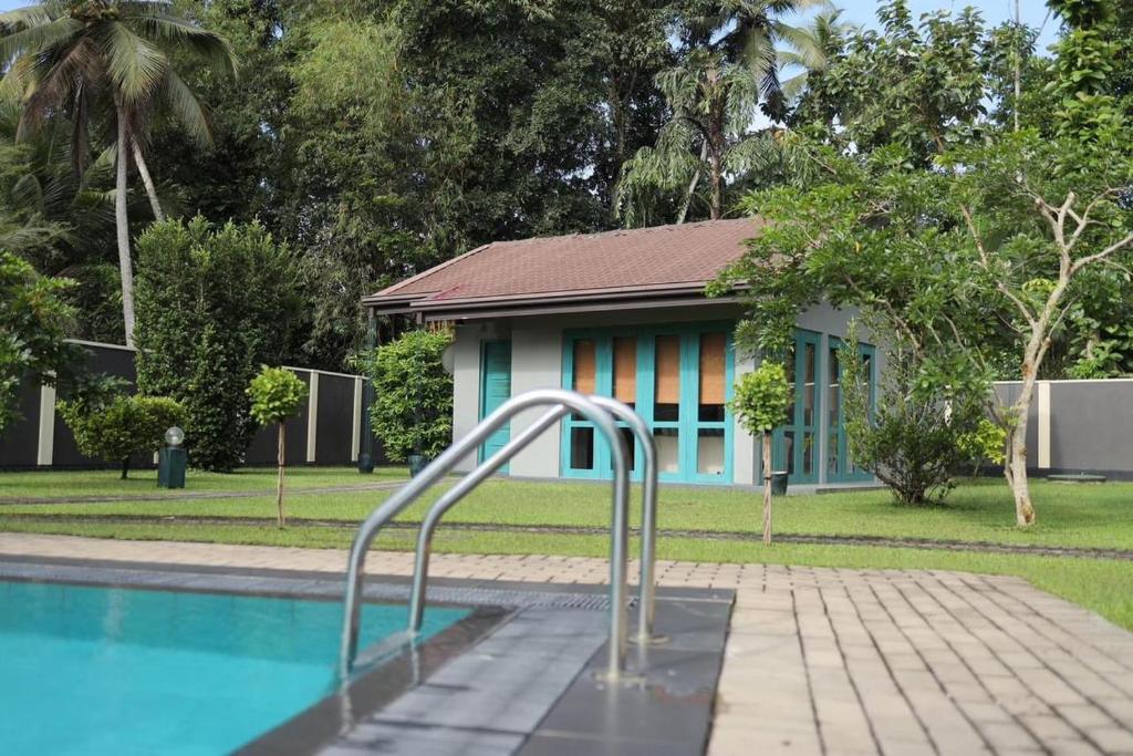 een resort met een zwembad en een gebouw bij J Villa in Gampaha