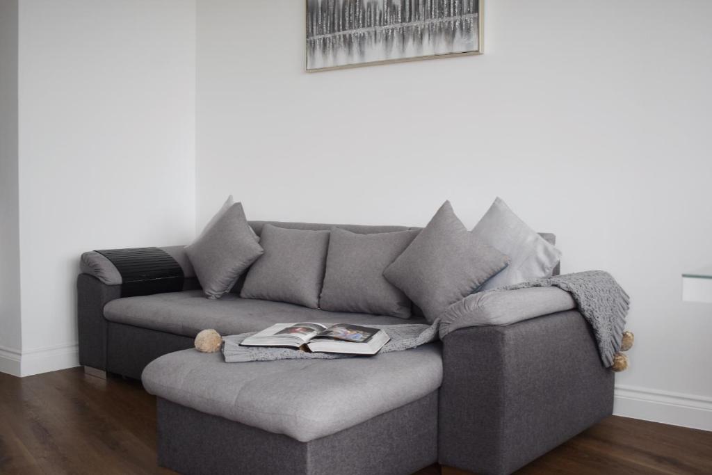 uma sala de estar com um sofá com um livro em Calming 2BR with balcony in Brentwood em Brentwood