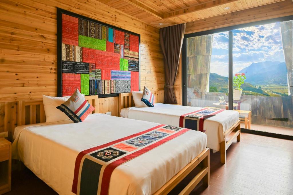 Duas camas num quarto com vista para a montanha em Arista Homestay em Sa Pa