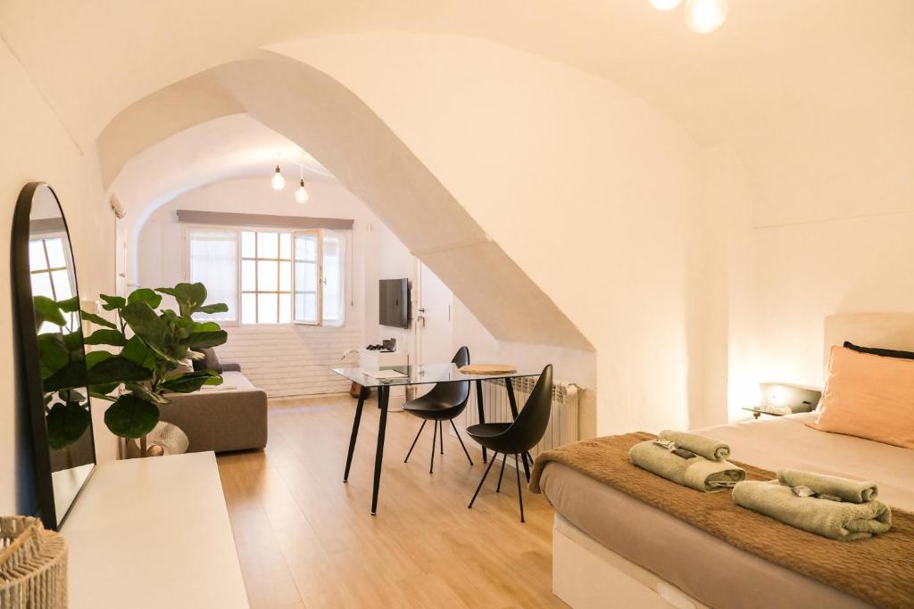 a bedroom with a bed and a living room at Casa Besalú - Estudio en el centro del pueblo in Besalú