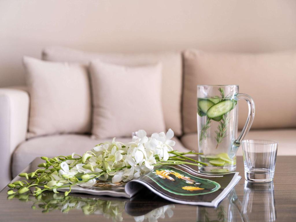 une table avec un vase d'eau et de fleurs sur elle dans l'établissement Rixos Alamein - Full Board Plus, à El Alamein