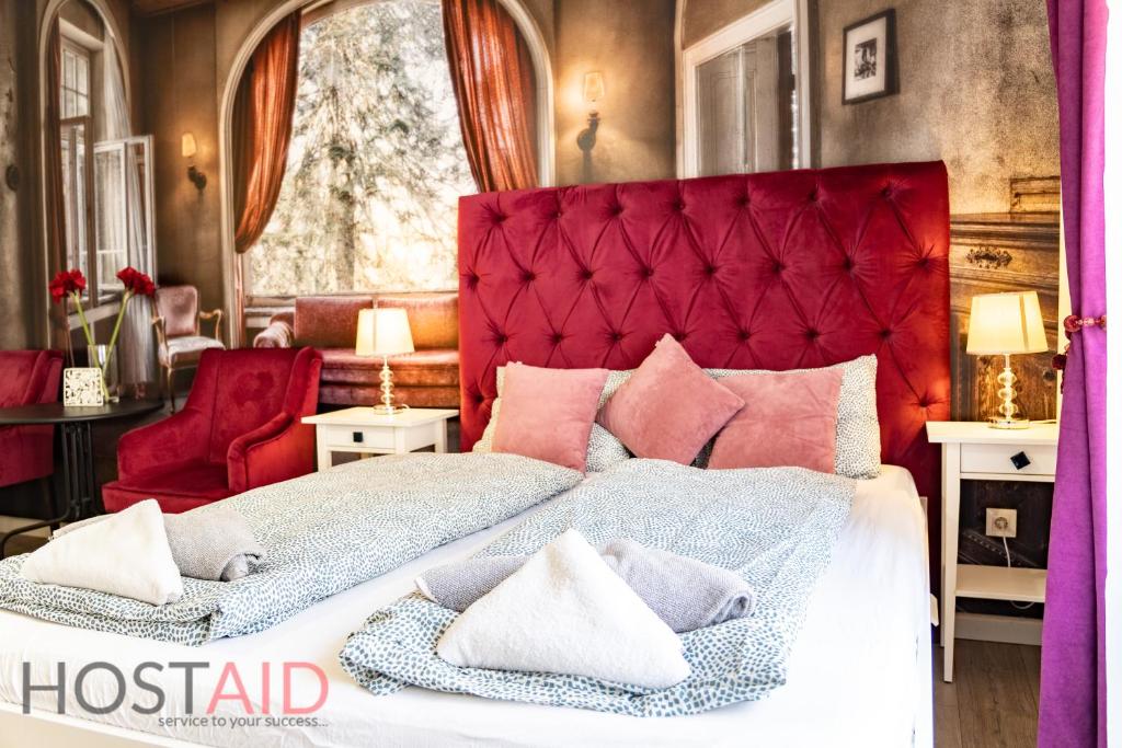 une chambre avec un grand lit avec une tête de lit rouge dans l'établissement DH30 Apartments - Budapest - hostAID, à Budapest