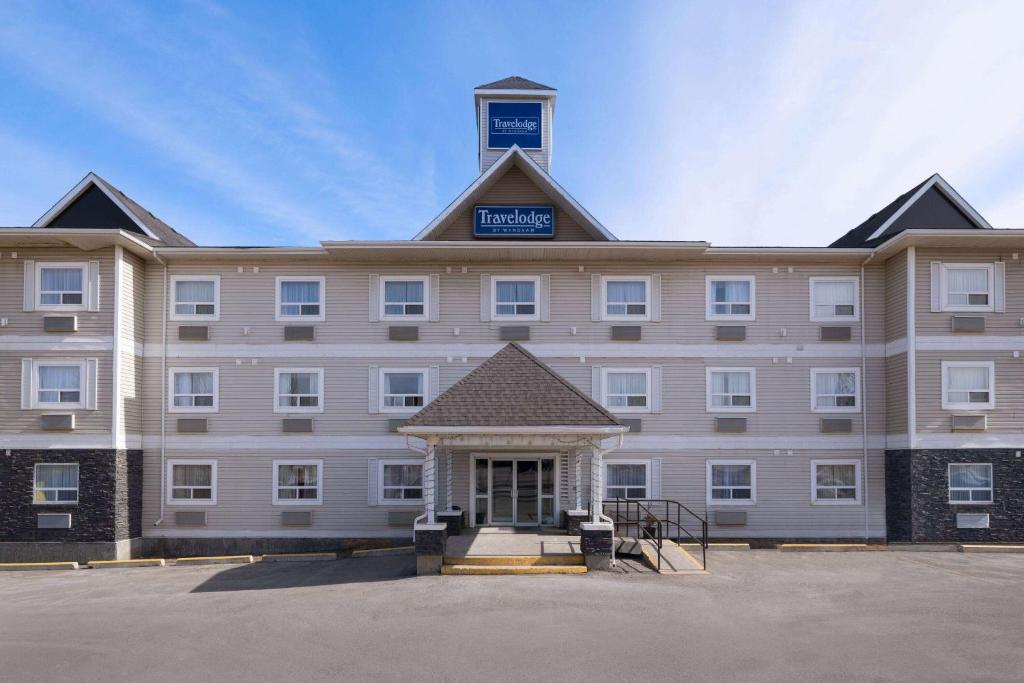 a large building with a sign on top of it at Travelodge by Wyndham Fort McMurray in Fort McMurray