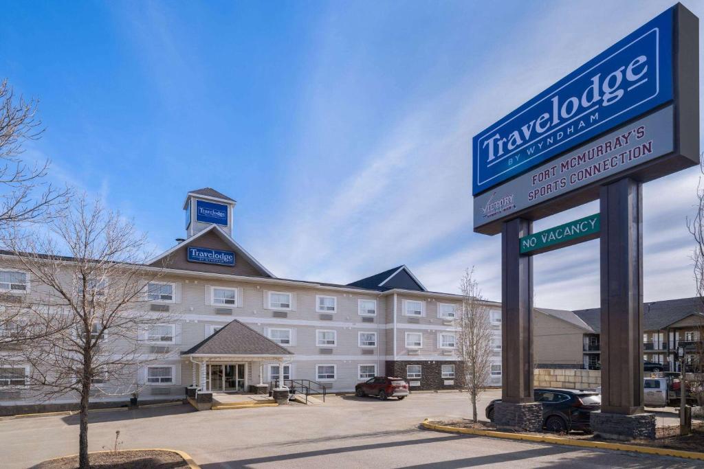 a hotel with a sign in front of a building at Travelodge by Wyndham Fort McMurray in Fort McMurray