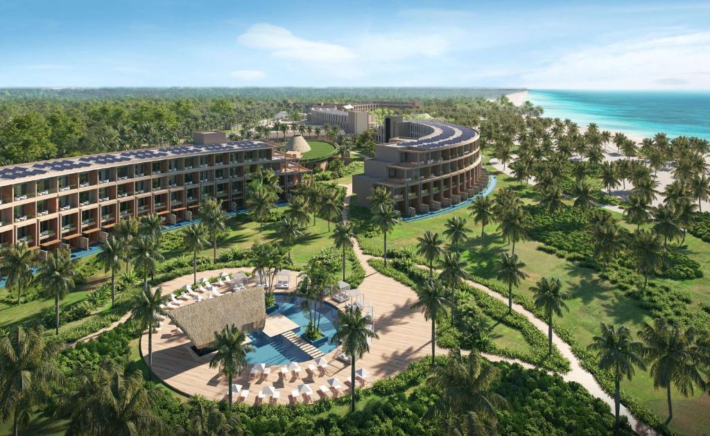 uma vista aérea do resort com palmeiras e do oceano em Zemi Miches All-Inclusive Resort, Curio Collection By Hilton em Miches