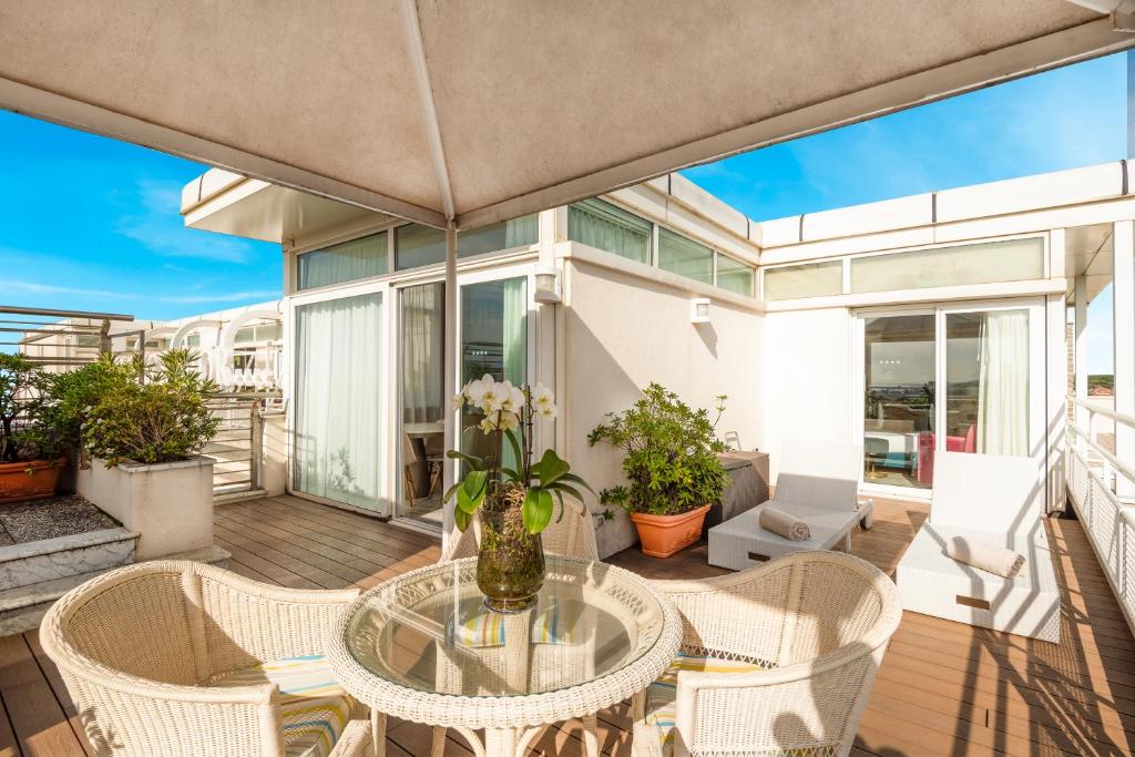 a patio with a glass table and chairs at Hotel Excelsior in Marina di Massa