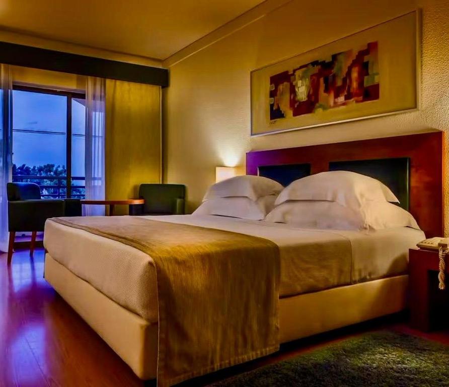 une chambre avec un grand lit dans une pièce dans l'établissement Semanas 30 e 24 Vila Galé Cerro Alagoa, à Albufeira