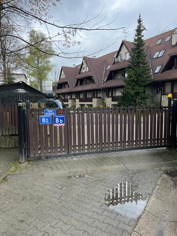 a wooden fence in front of a house at Apartament Śnieżka in Zakopane