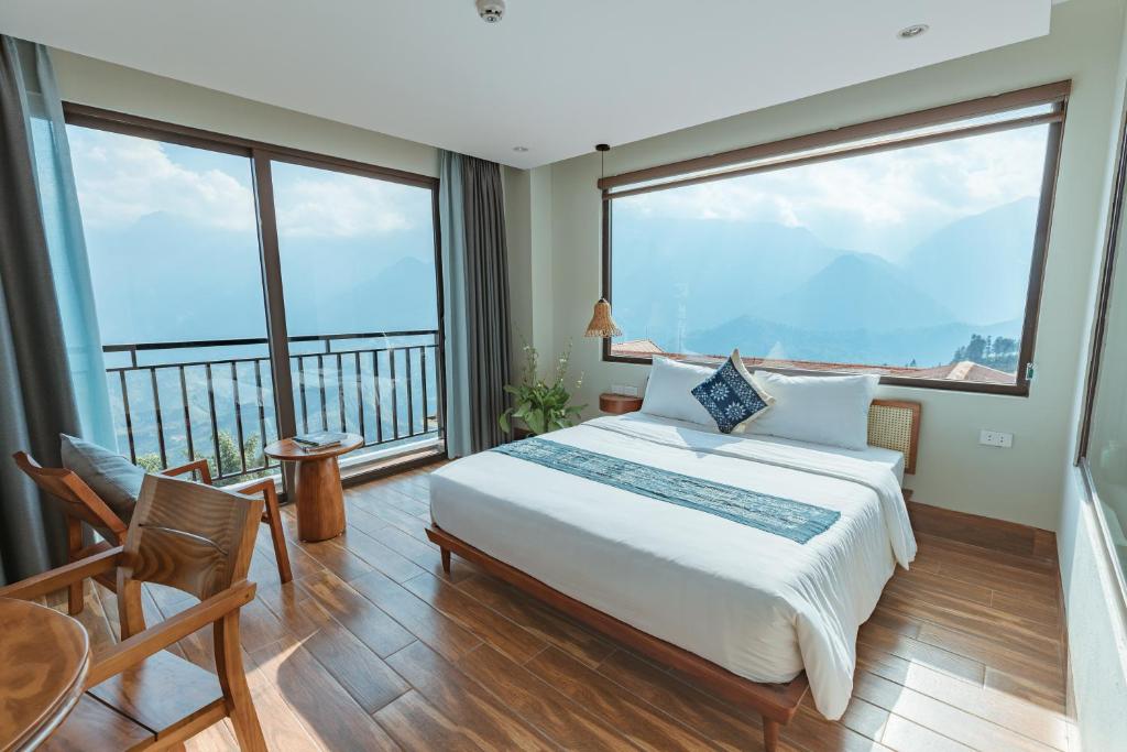 a bedroom with a large bed and large windows at Sapa Yen Hotel in Sa Pa