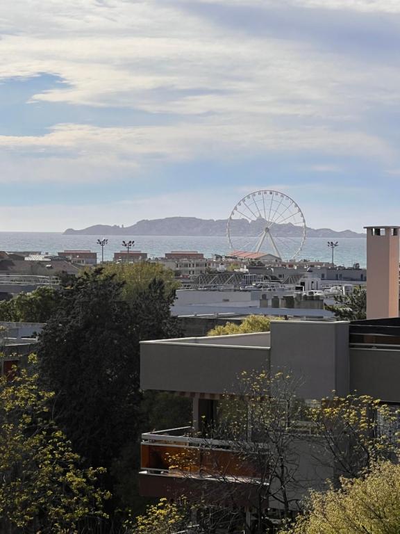 une vue sur une ville avec une roue ferris au loin dans l'établissement Appartemment Cozy Vue sur Mer, à Marseille