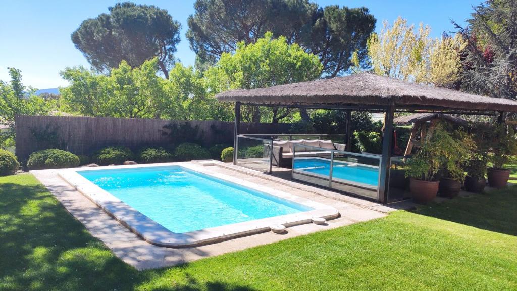 una piscina en un patio con cenador en Saika Rural, en Manjirón