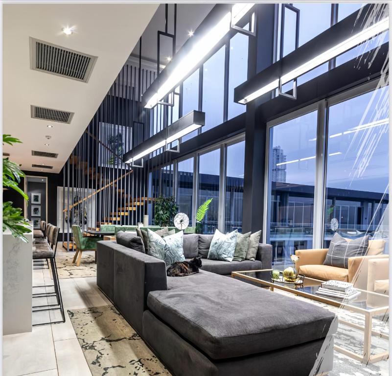 a living room with couches and tables in a building at The RoyalPlatinum Penthouse in Johannesburg