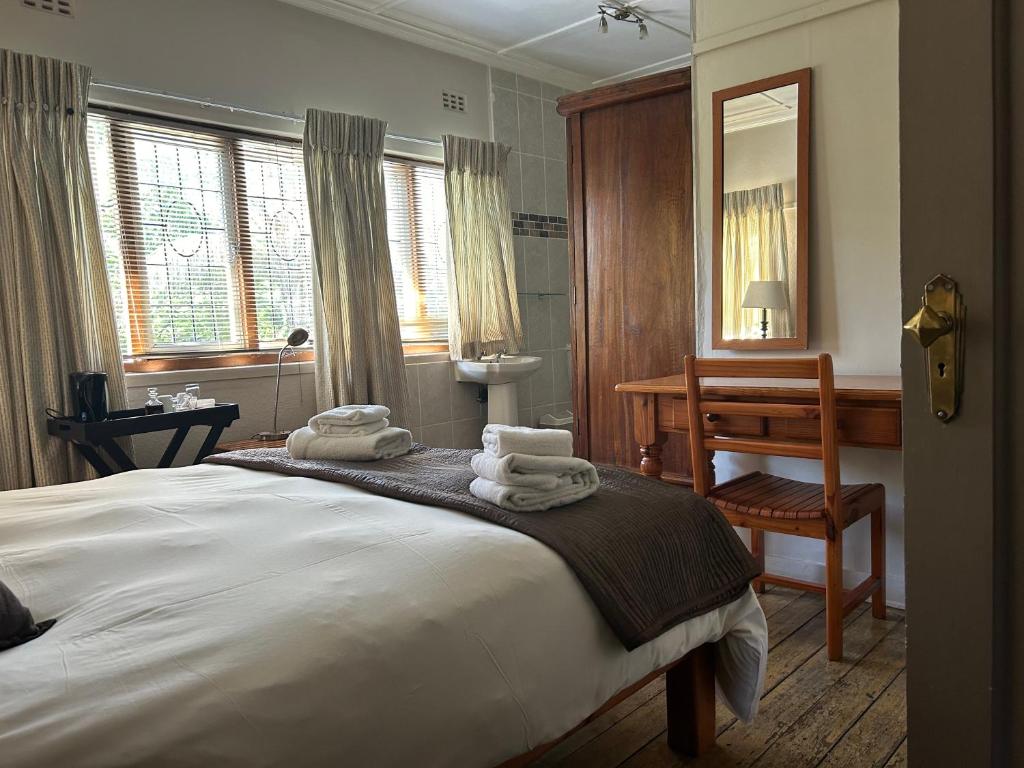 a bedroom with a bed with towels on it at Pebble Fountain Guesthouse in Pretoria