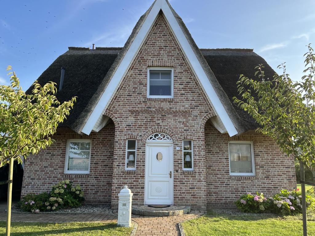 una casa de ladrillo rojo con puerta blanca en Reethaus Meerferien, en Poseritz