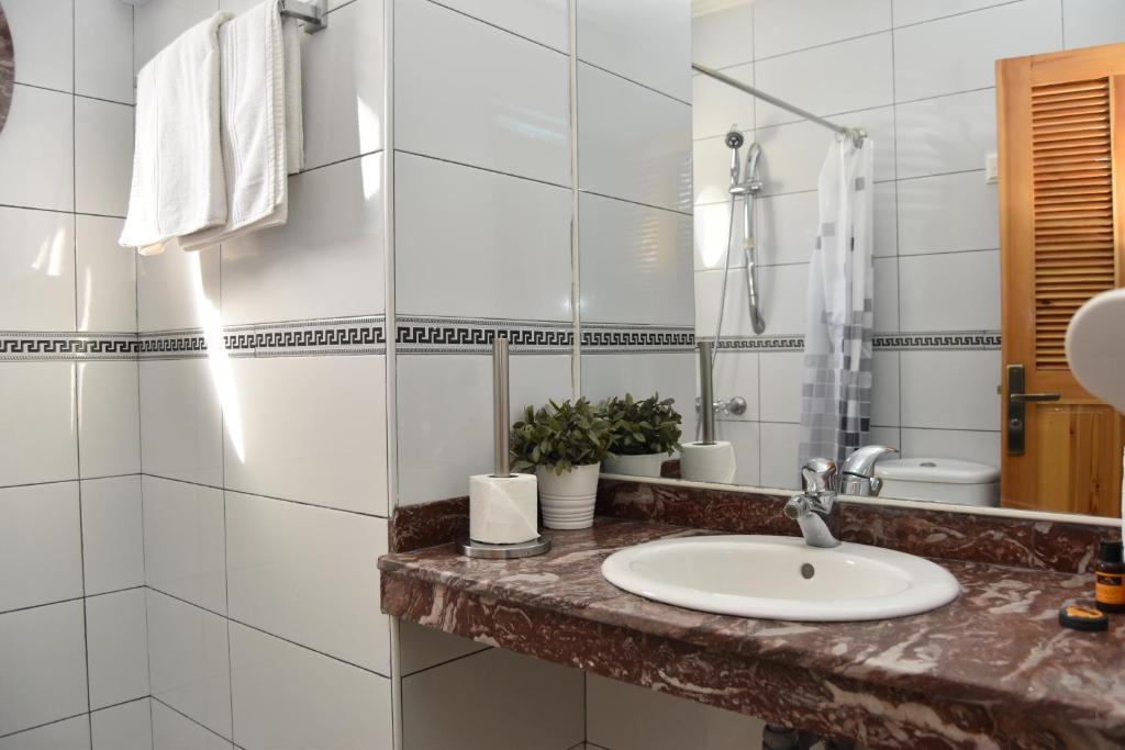 a bathroom with a sink and a mirror at Hotel L'Initiale in Oualidia