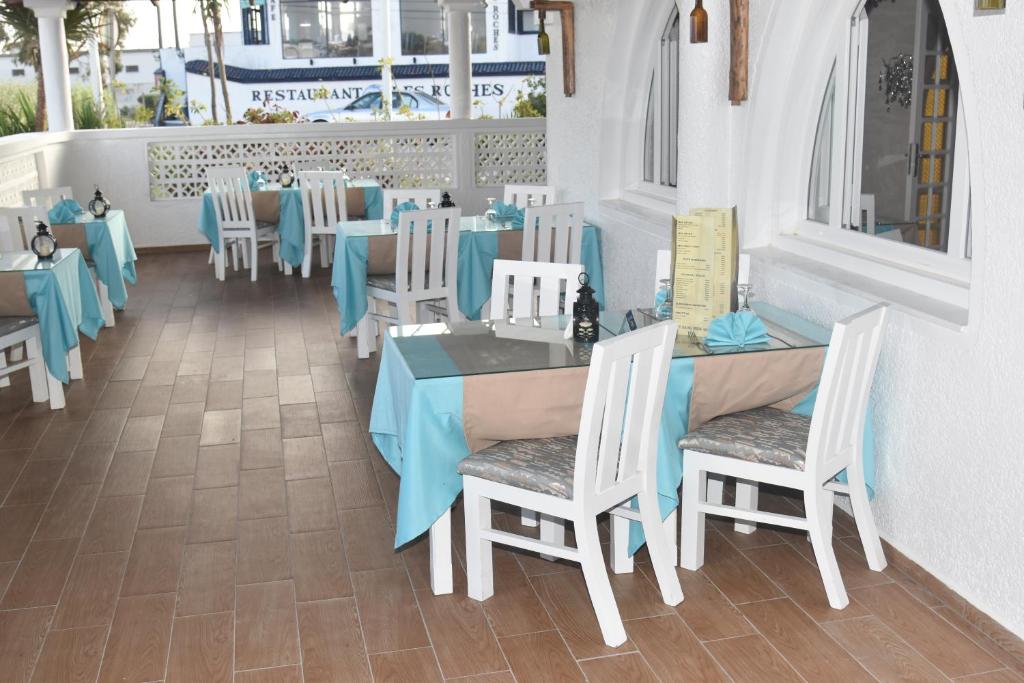 a dining room with blue tables and chairs at Hotel L'Initiale in Oualidia