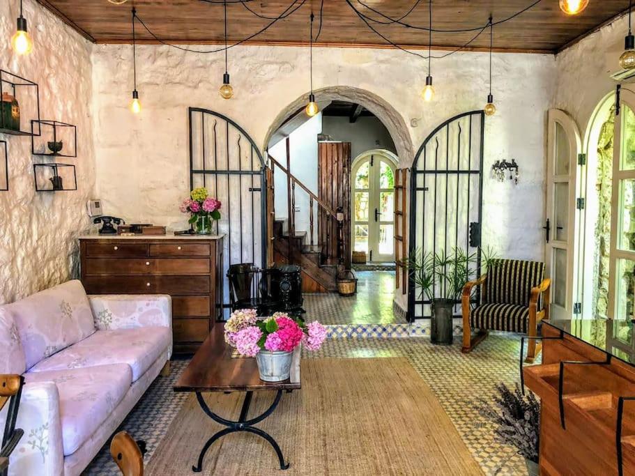 - un salon avec un canapé et une table dans l'établissement Original stone house with patio in the city center, à Alaçatı