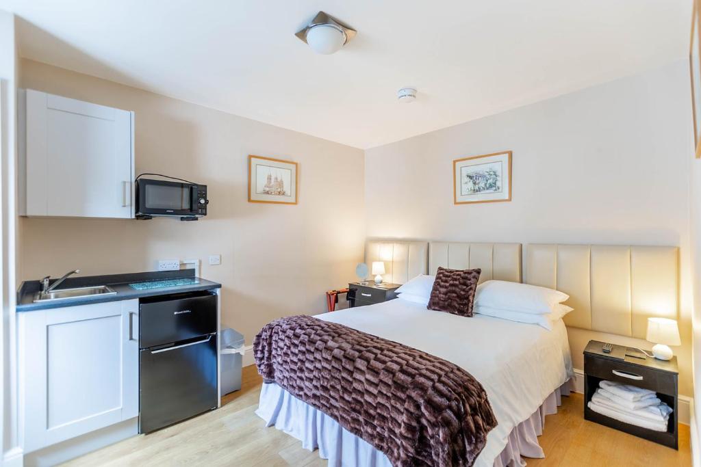 a small bedroom with a bed and a sink at Roger Ground Guest House - with Onsite Car Parking in Windermere
