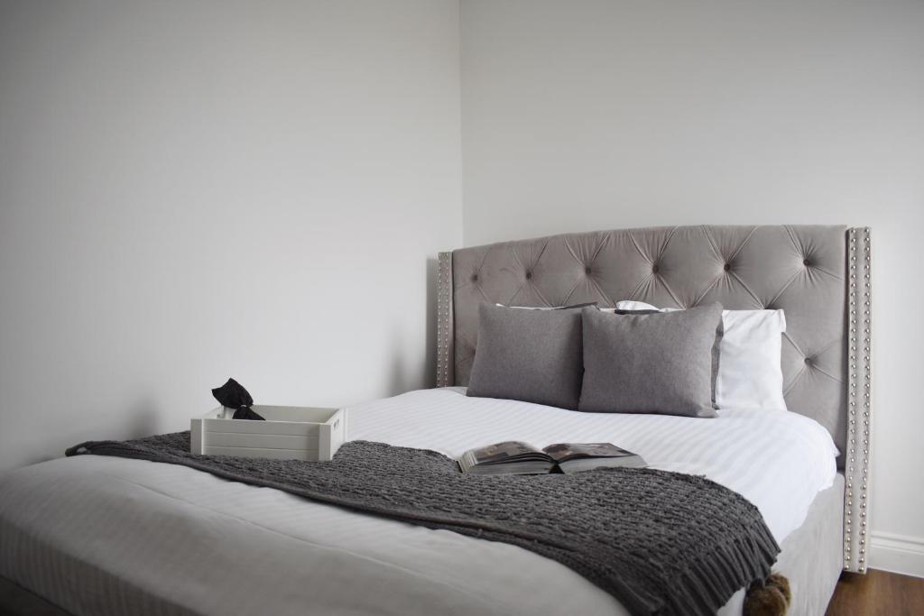 een slaapkamer met een bed met twee boeken erop bij Stylish 2BR in Brentwood in Brentwood