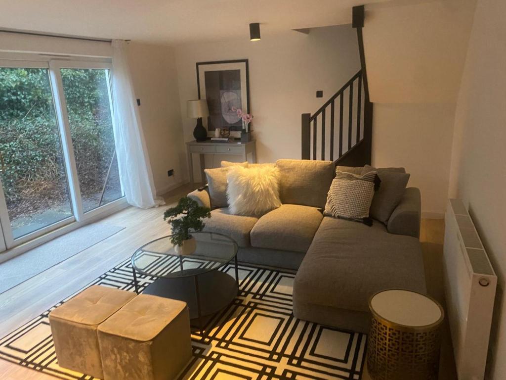 a living room with a couch and a table at Sleeps7-Parking-Garden-Patio in Johnstone